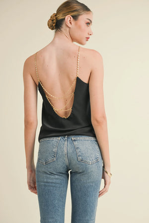 Get ready to turn heads with the Reset by Jane | Sophia Cami Top. Featuring an open back and chain straps, this top adds a touch of edgy elegance to any outfit. The chain wrap back detail and regular fit provide a flattering silhouette, while the solid color silky fabric elevates your style game. Truly a must-have piece for any fashion-forward individual!