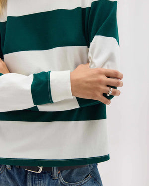Person wearing a green and white striped sweater with a plain background
