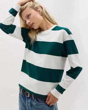 Woman wearing a green and white striped sweater on a plain background