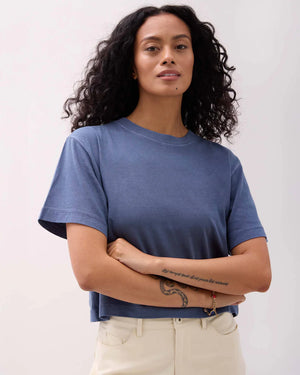 Woman wearing a blue t-shirt against a plain background