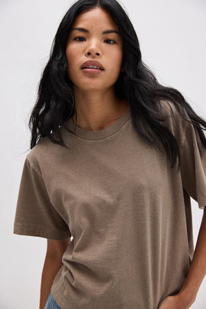 Woman wearing a brown t-shirt against a white background