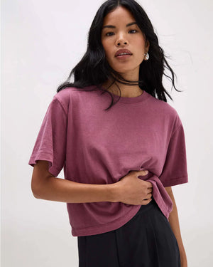 Woman wearing a mauve t-shirt against a white background