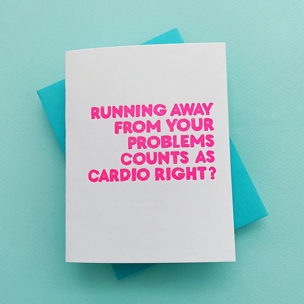 Card with pink text on a white card over a turquoise envelope against a light blue background