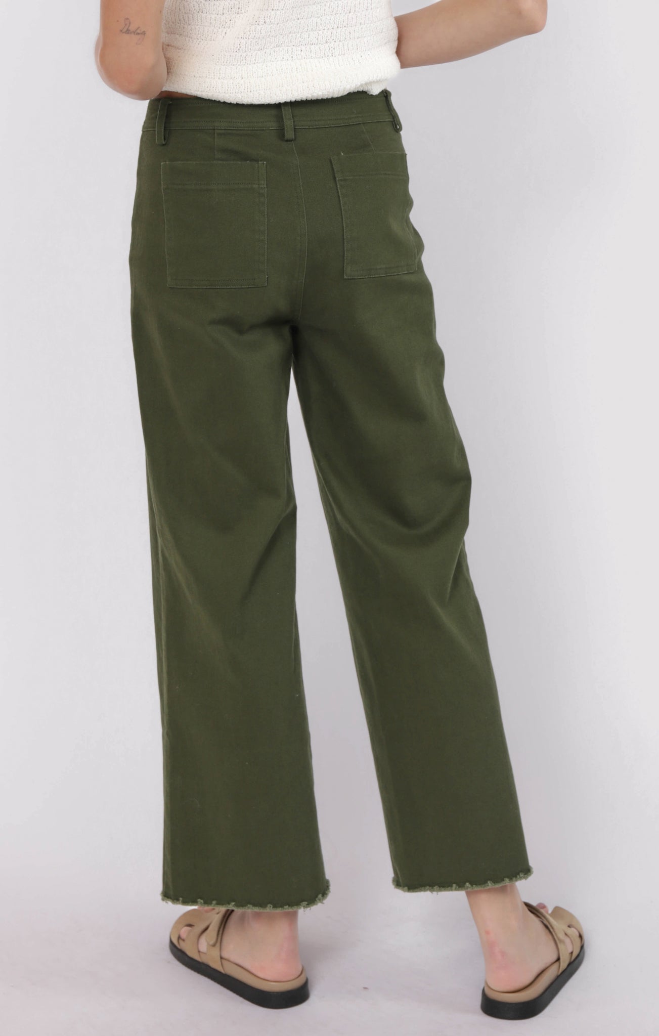 Person wearing olive green pants on a white background