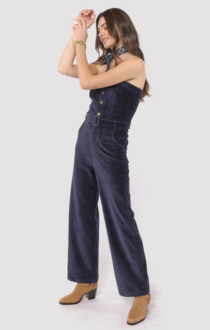 Woman wearing a navy blue jumpsuit on a white background