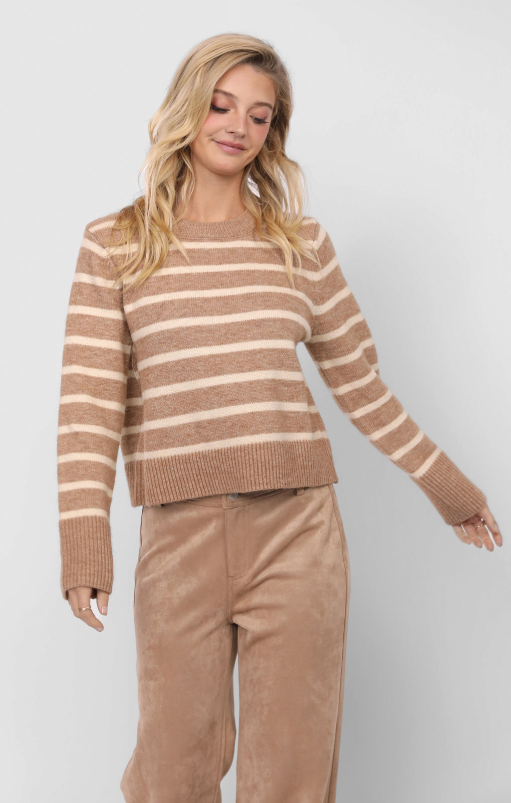 Woman wearing a brown and beige striped sweater with matching pants on a white background