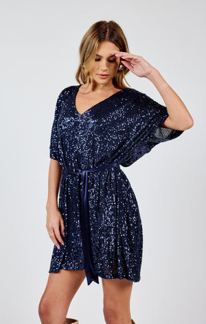 Stand out from the crowd in this dazzling v-neck sequin dress by Sadie &Sage. The tie belt adds the perfect touch of flair to this sky high dress. Bring on the compliments (and the dance floor)!