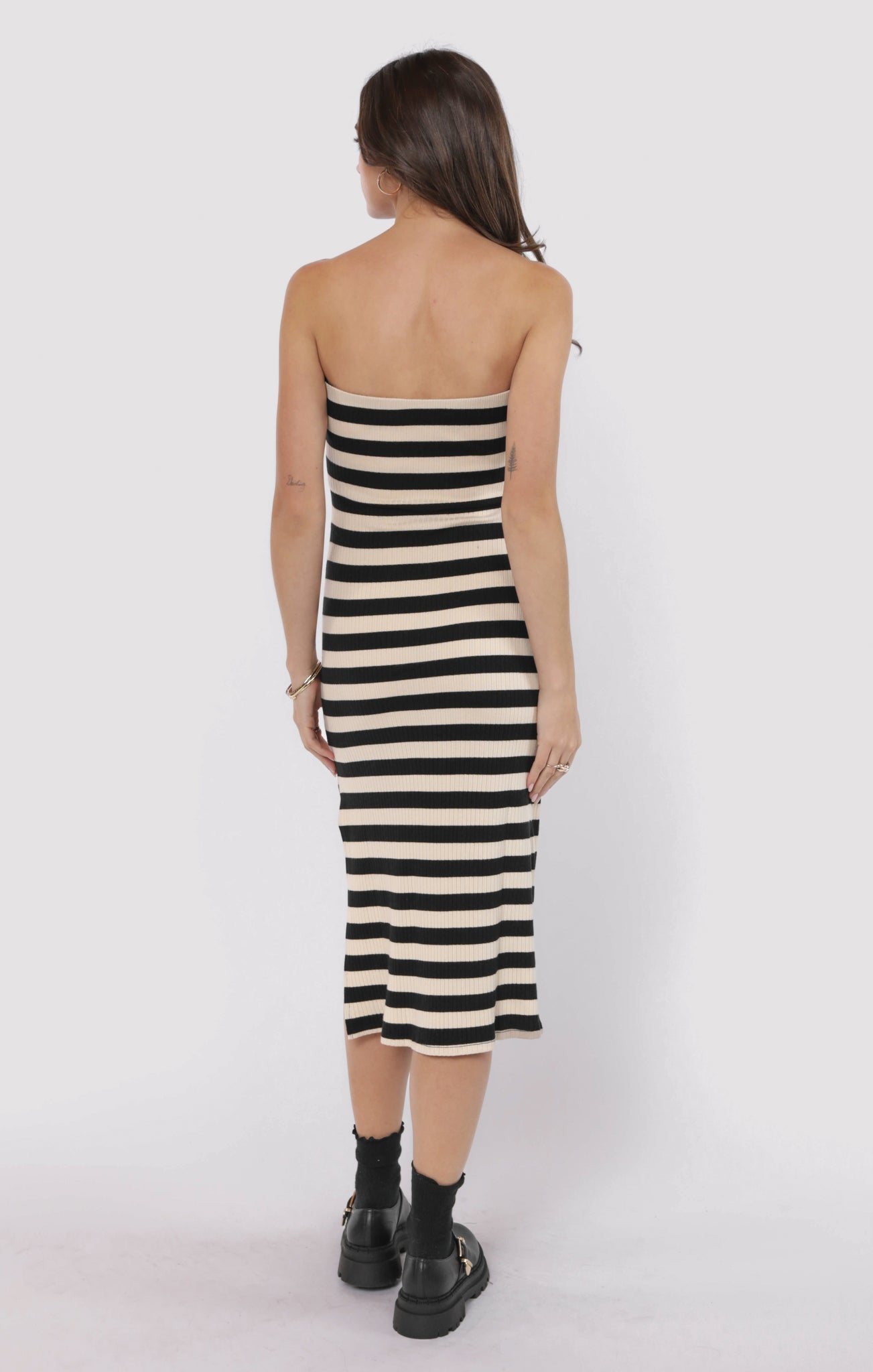 Woman wearing a black and white striped dress on a white background