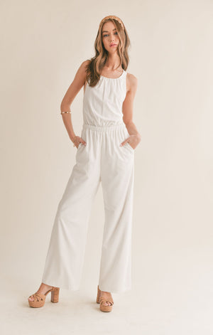 Feel confident and chic in the Sage the Label Assured jumpsuit with a playful crossed back. Perfect for a night out or a casual day, this jumpsuit effortlessly combines style and comfort. Say goodbye to boring outfits and hello to a quirky, fun look!