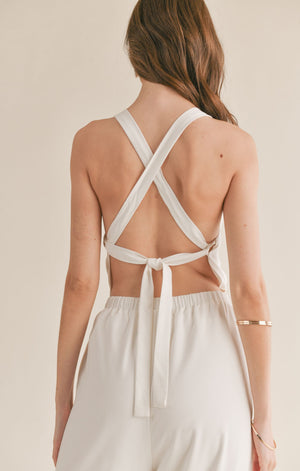 Feel confident and chic in the Sage the Label Assured jumpsuit with a playful crossed back. Perfect for a night out or a casual day, this jumpsuit effortlessly combines style and comfort. Say goodbye to boring outfits and hello to a quirky, fun look!