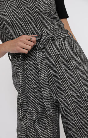 Person wearing a black and white herringbone patterned outfit with a tie waist.