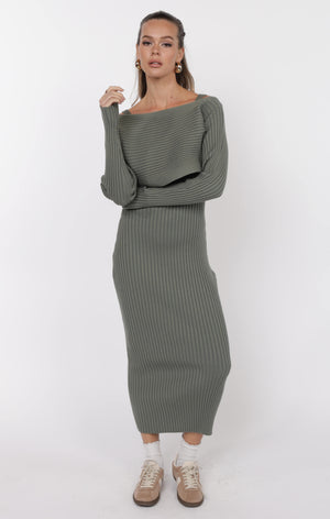 Woman wearing a green ribbed knit dress on a white background