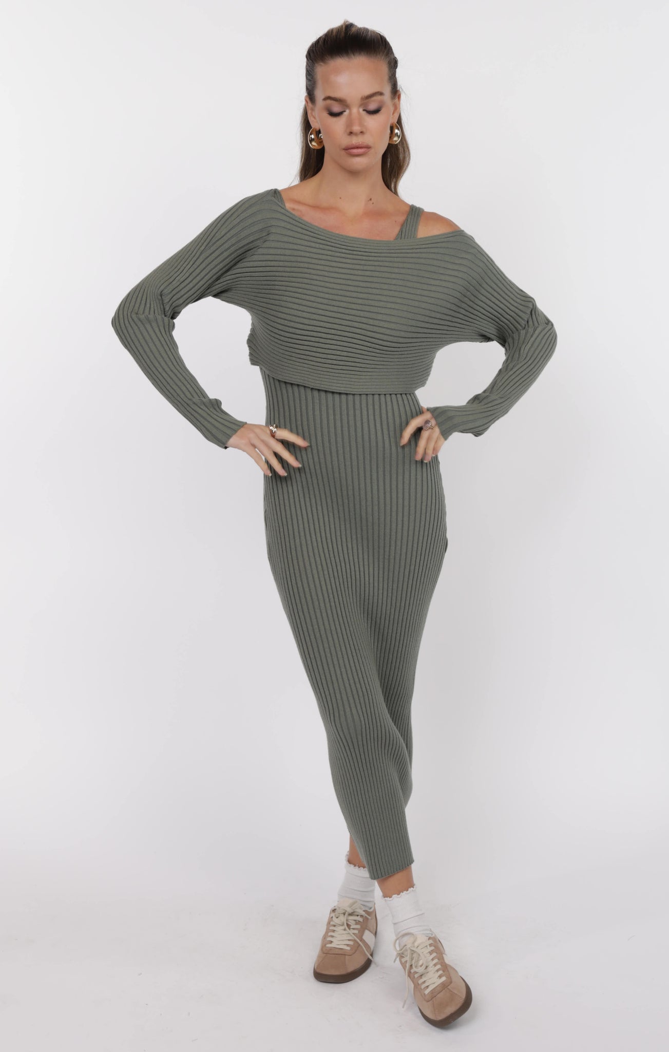 Woman wearing a green ribbed knit outfit on a white background