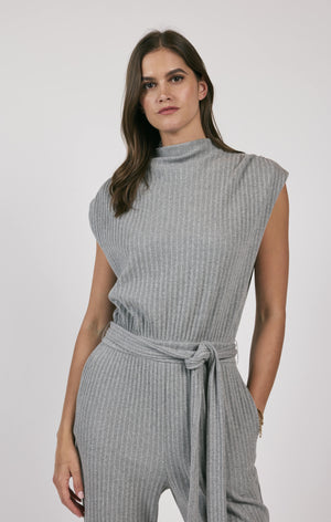 This rib knit jumpsuit hugs your curves and adds a touch of playfulness with a belted waist. Less is truly more with this versatile piece, perfect for a variety of occasions.