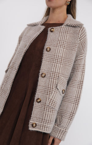 Person wearing a textured brown coat with a white background