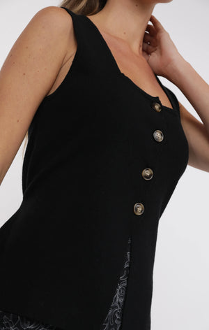 Black sleeveless dress with button details on a neutral background