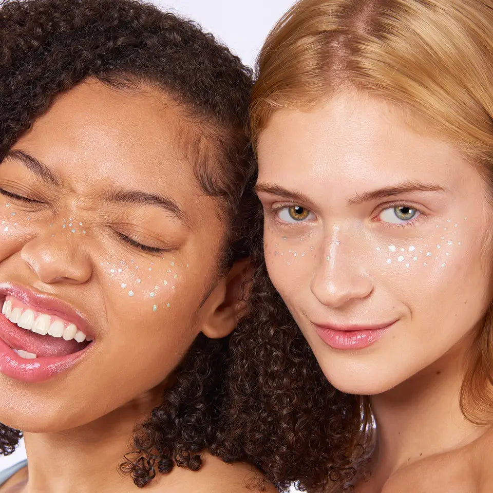 Two women with a product on their faces against a white background