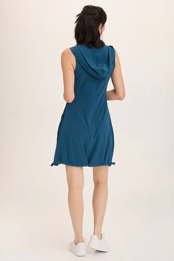 Woman wearing a teal dress with a hood on a white background
