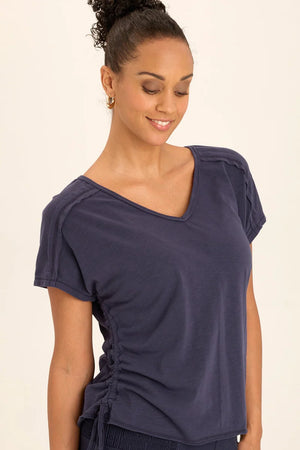 Cinchable side cords grace this v-neck slub jersey top; also featuring a front yoke, dolman sleeves, and raw-edge details throughout.