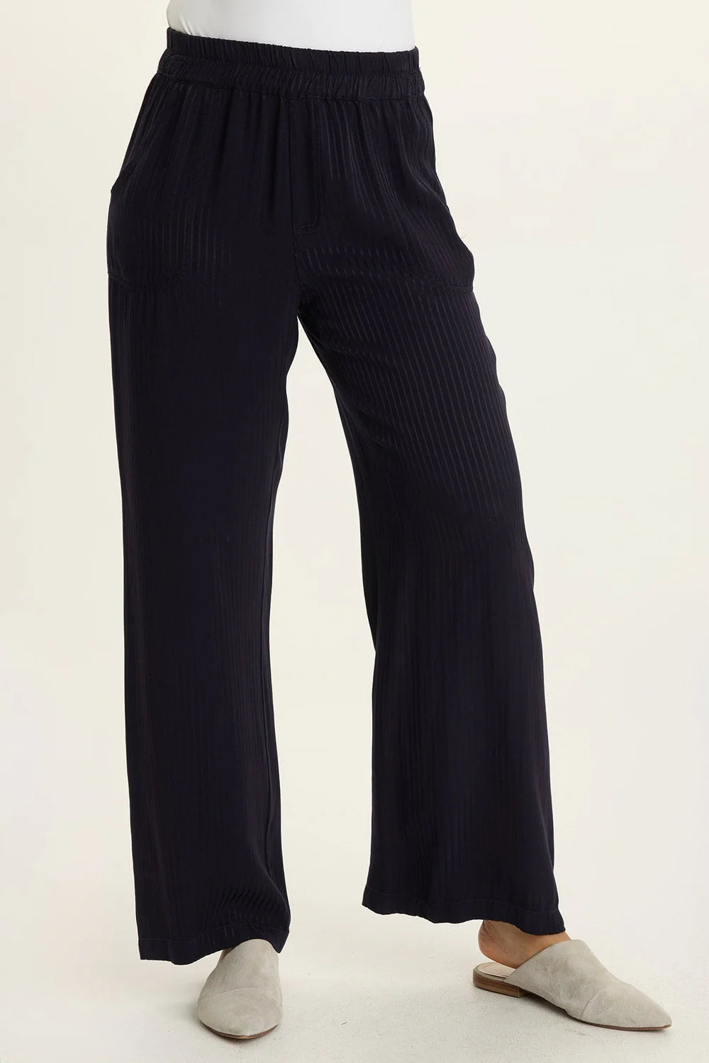 Black ribbed pants worn by a person on a white background