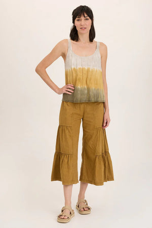 Woman wearing a sleeveless top and tiered pants on a white background