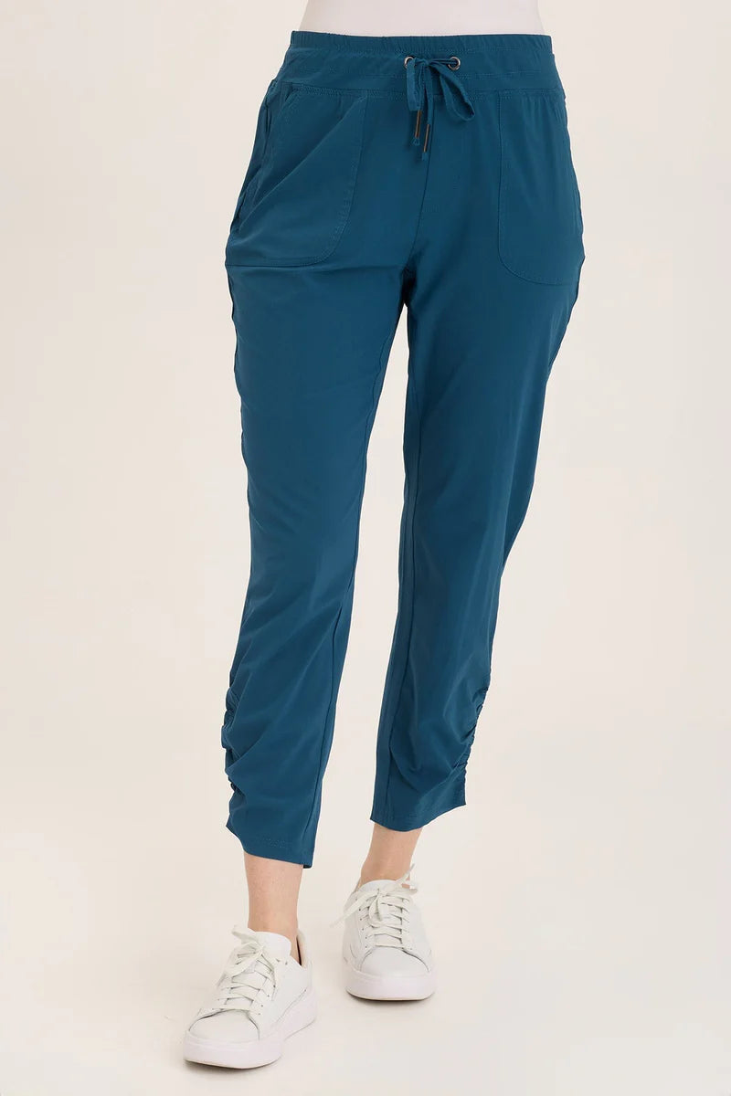 Teal jogger pants worn by a person on a white background