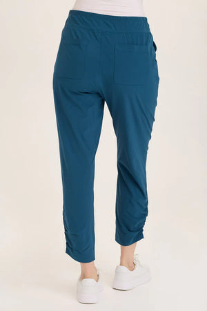 Teal pants worn by a person on a white background