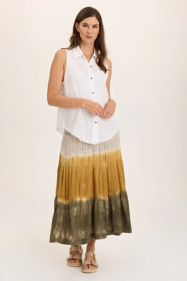 Woman wearing a sleeveless white blouse with a gradient skirt on a plain background