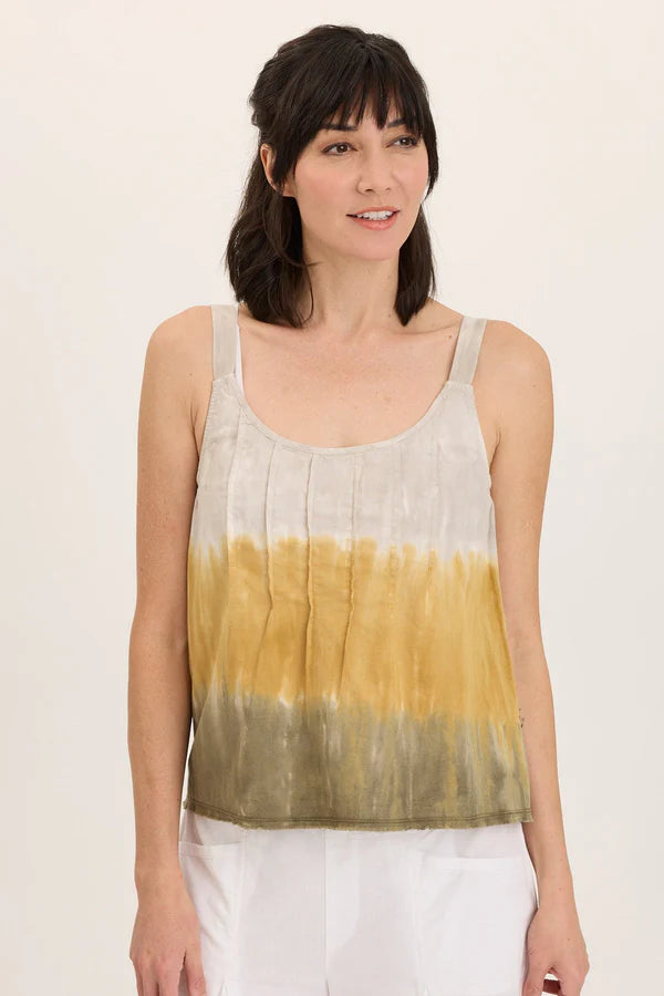 Woman wearing a sleeveless top with a gradient design on a plain background