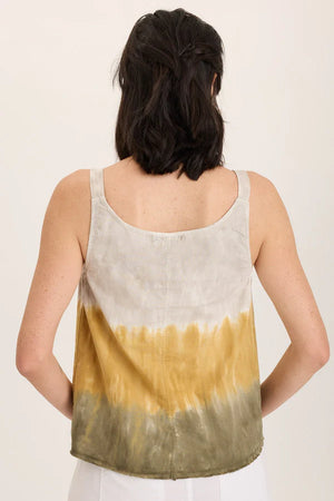 Woman wearing a sleeveless top with a gradient design on a plain background