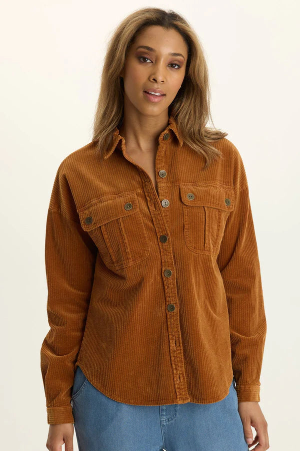Woman wearing a brown corduroy shirt against a plain background