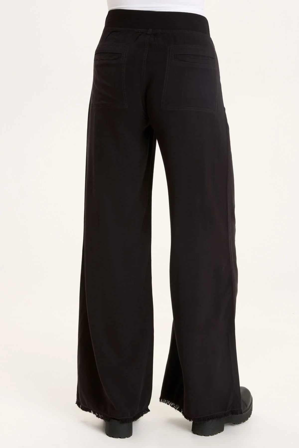 This wide leg trouser is now in our super soft Taissa. A pull-on elastic waistband and a faux fly, style lines with raw edges, back pockets, and raw edge hems.