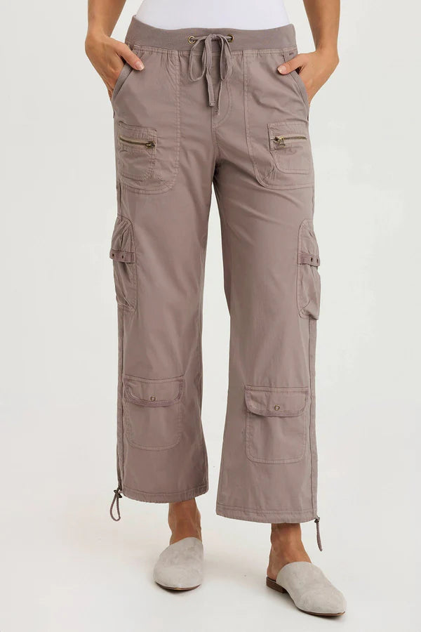 Person wearing beige cargo pants on a white background