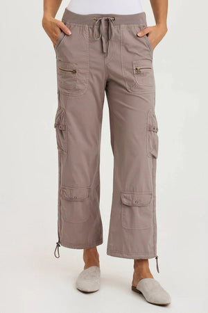 Person wearing beige cargo pants on a white background
