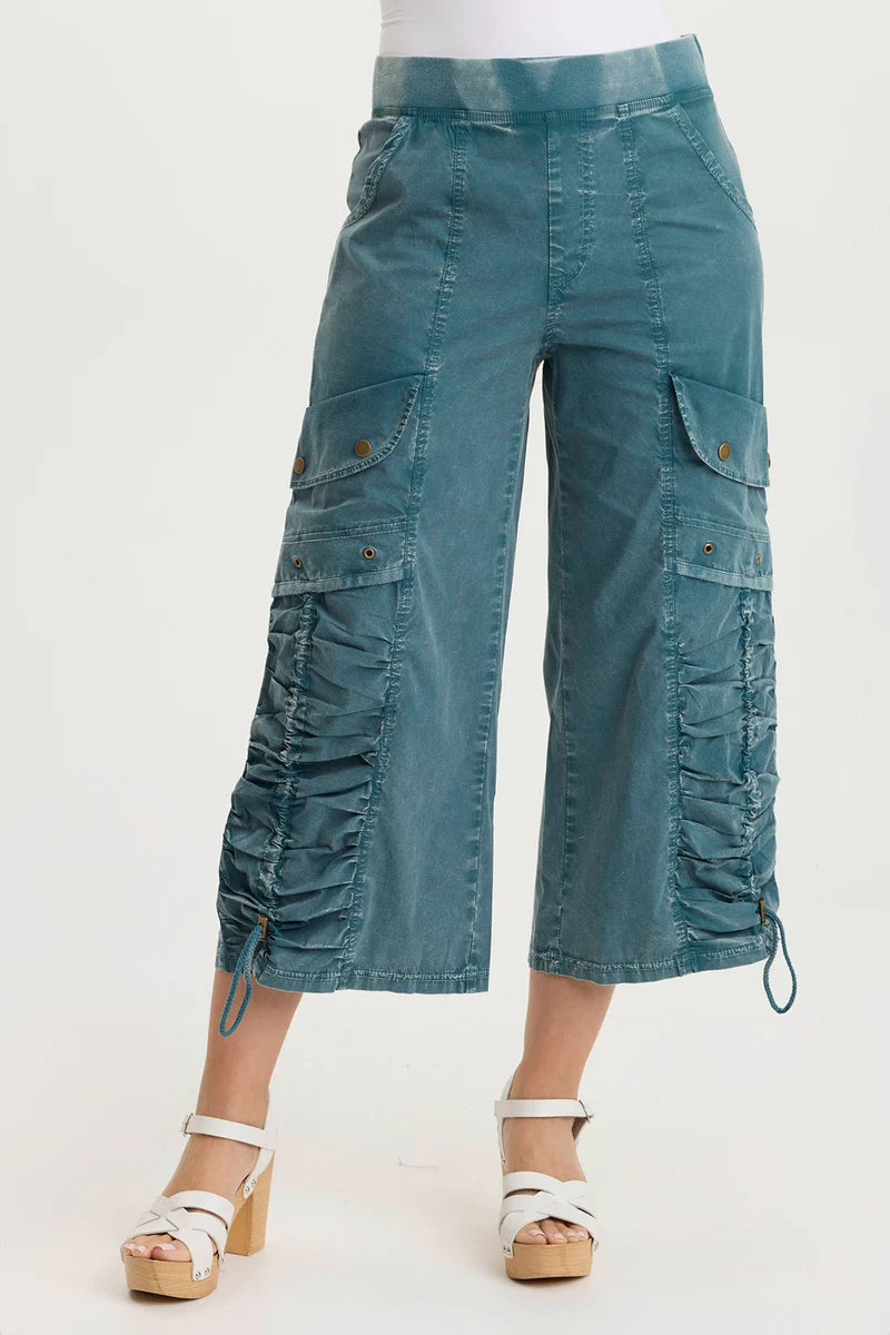 Teal cargo pants worn by a person on a white background