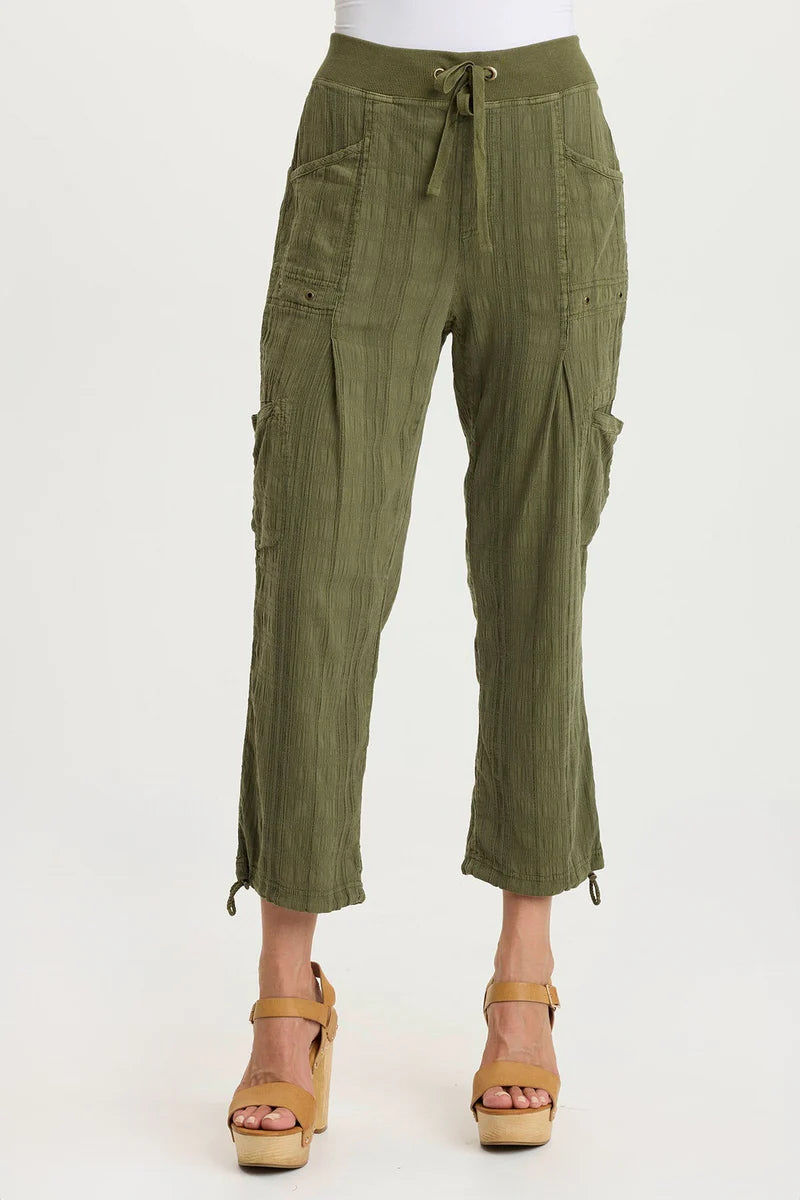 Green cargo pants worn by a person on a white background