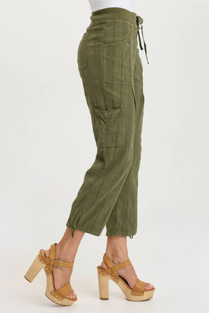Green cargo pants worn by a person on a white background