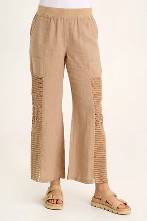 A linen pull-on waist, wide leg with a circular design, crochet leg panels, and front and back pockets make up the Tangent Pant.