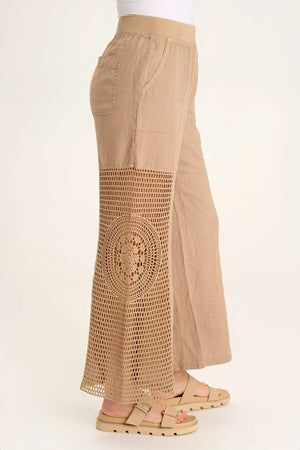 A linen pull-on waist, wide leg with a circular design, crochet leg panels, and front and back pockets make up the Tangent Pant.