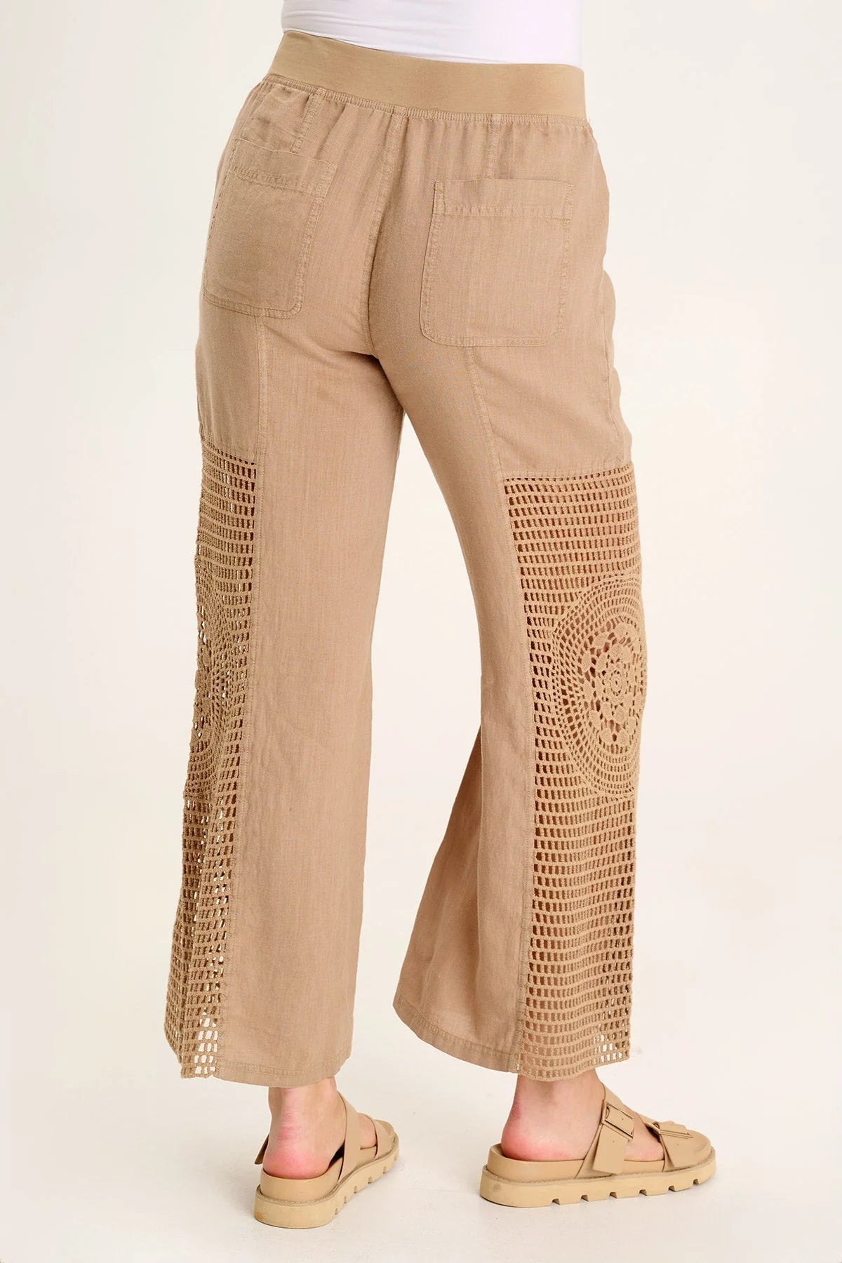 A linen pull-on waist, wide leg with a circular design, crochet leg panels, and front and back pockets make up the Tangent Pant.