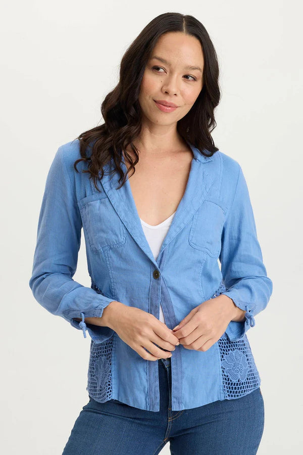 Woman wearing a blue textured jacket over a white top on a white background