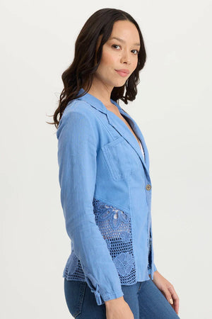 Woman wearing a blue blazer with lace detailing on a white background