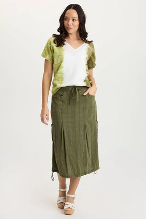 Woman wearing a green top and olive green skirt on a white background