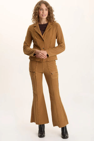 Woman wearing a brown suit with flared pants on a white background
