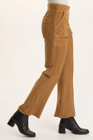 Tan corduroy pants worn by a person on a white background