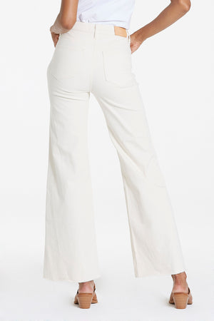 High rise wide leg jeans. It's cozy fit that sits at natural waist, embraces your natural curves and accentuates your hips and thigh. Full inseam on stretch denim featuring cut-off hem details add flair to these soft pants, available in designer colors, and finished with a center inseam press for a tailored look.