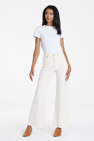 High rise wide leg jeans. It's cozy fit that sits at natural waist, embraces your natural curves and accentuates your hips and thigh. Full inseam on stretch denim featuring cut-off hem details add flair to these soft pants, available in designer colors, and finished with a center inseam press for a tailored look.